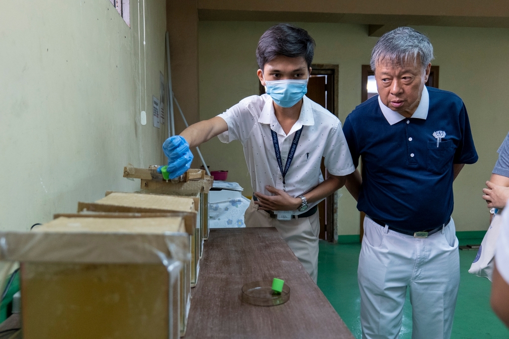 Chemical engineer Ace Angeles (left) shows  Tzu Chi volunteer Johnny Kwok the plastic caps that serve as biofilm carriers.