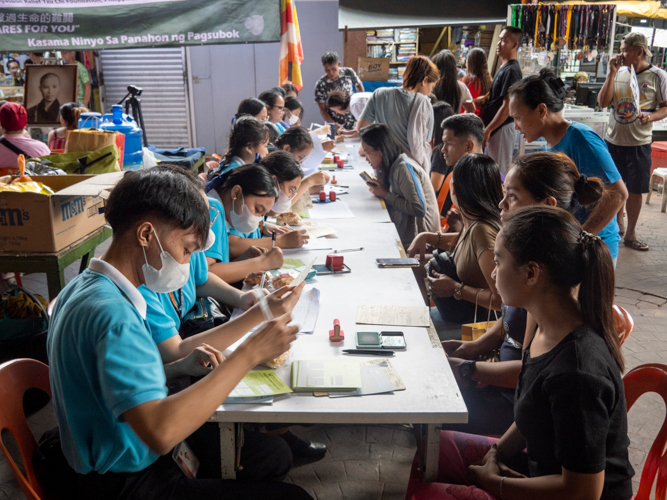 Tzu Chi scholars and youth volunteers helped in the distribution of relief stubs for 387 families.