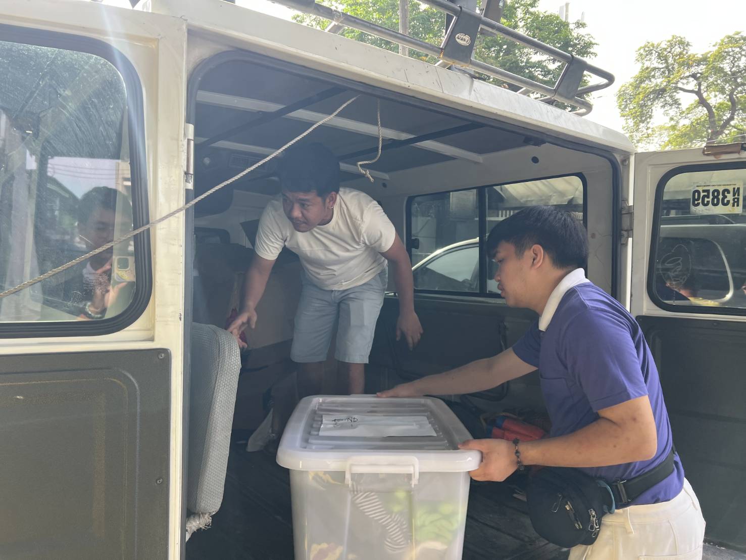 John Davidson Luy helps unload boxes of thrifted clothing in preparation for a sale that he organized for three days in December 2025.  