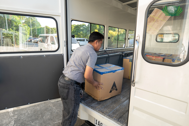 Tzu Chi staff unload boxes containing face masks for school distribution.