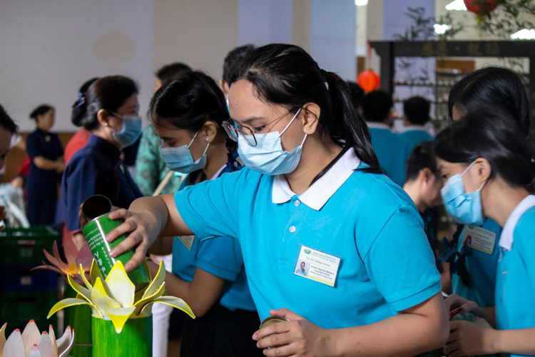 At the end of the Year Eng Blessing Ceremony, participants take turns pouring their collected coin donations in a large container for Tzu Chi’s charity programs.