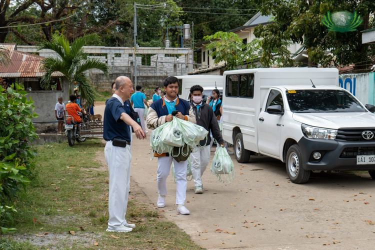 Arriving in Porac, Pampanga, students help in unloading the school supplies.