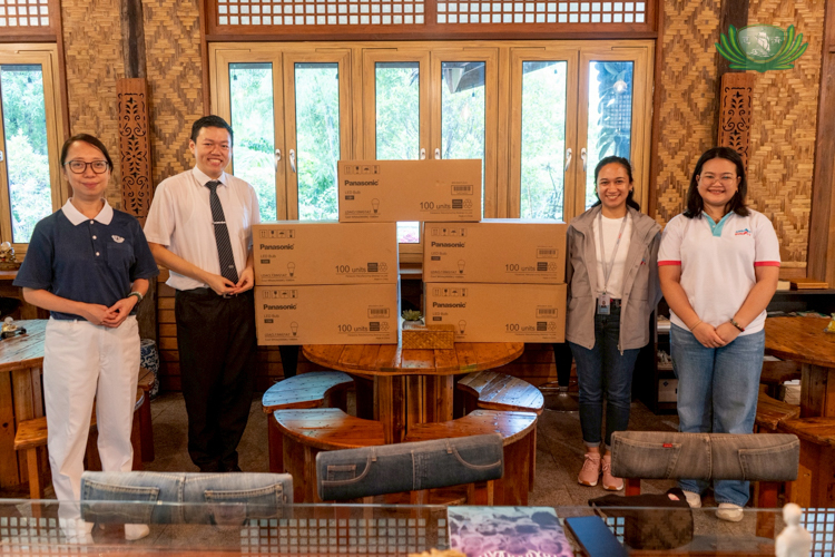 Representatives from Angat Buhay (right) receive over 500 units of Panasonic light bulbs from Tzu Chi volunteers.