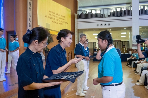 A new scholar receives her Tzu Chi ID from Tzu Chi Philippines Deputy CEO Woon Ng.