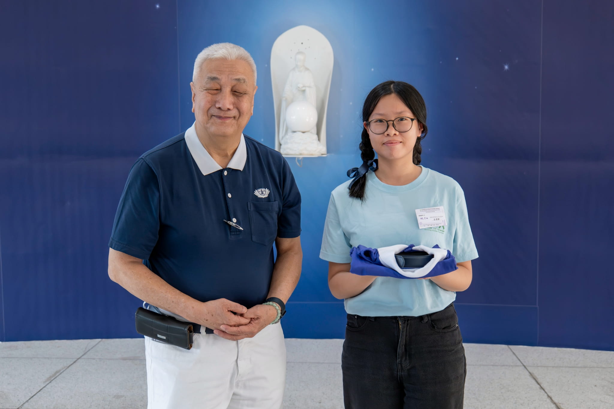Jessica Michelle Dy Victoria (right) receives her Tzu Chi uniform from Tzu Chi Philippines CEO Henry Yuñez.