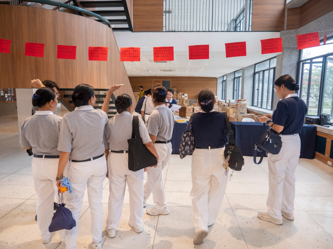 Blending tradition with fun, volunteers and guests engage in Chinese riddle-solving activities, with correct answers rewarded with fresh fruit, adding joy to the cultural celebration.