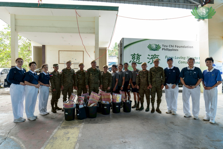 Tzu Chi volunteers pose together with members of the Philippine Army, showcasing teamwork in safety during the relief operations. 