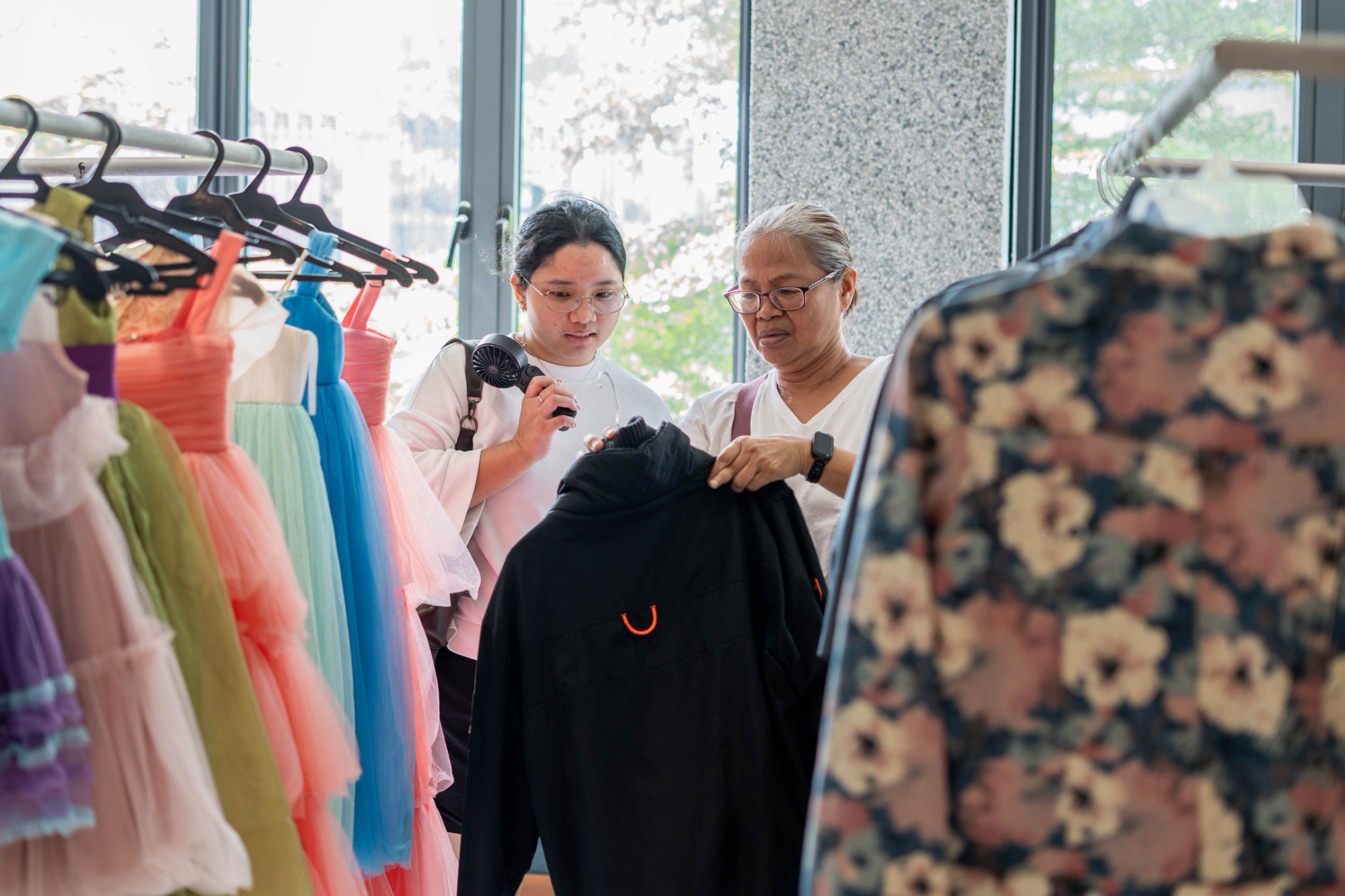 Sharing a heartwarming moment, a mother and daughter bond over selecting the perfect jackets together.