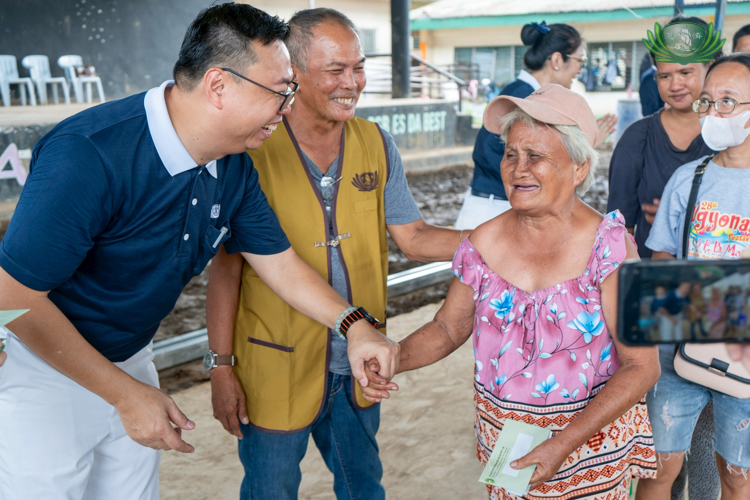 Tzu Chi volunteer Wilson Hung (left) led the team in La Carlota, where he greeted beneficiaries with a smile.