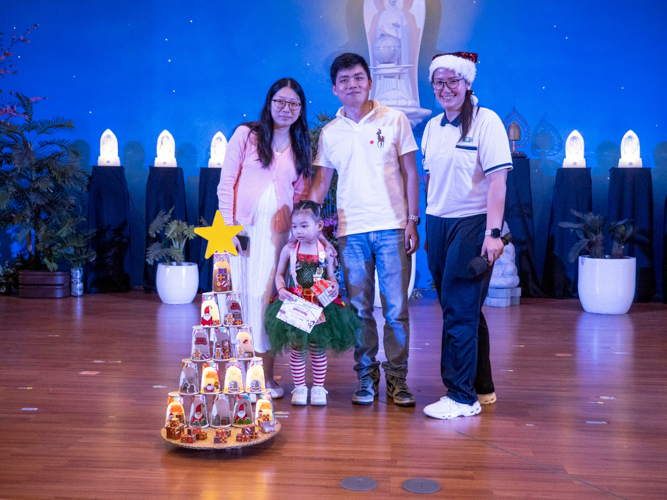 A student is given recognition for her creative Christmas tree, using repurposed coffee cups.