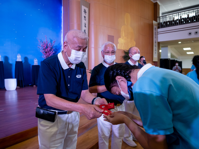 Tzu Chi Philippines CEO Henry Yuñez (left) presents a scholar with angpao【Photo by Daniel Lazar】