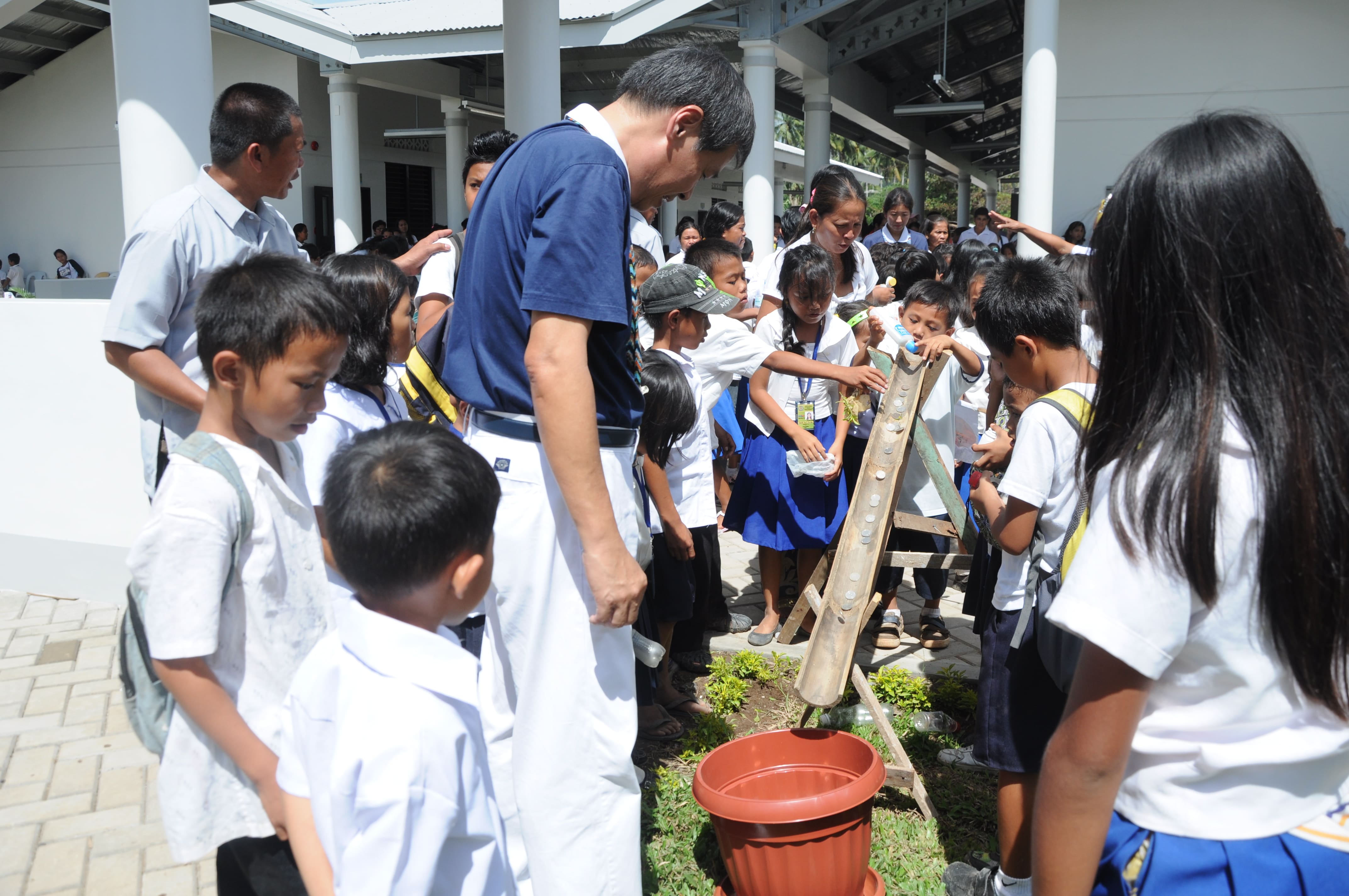 Mangayon Elementary School students place donations on a bamboo slide at the turnover ceremony of their newly built school on December 1, 2014.