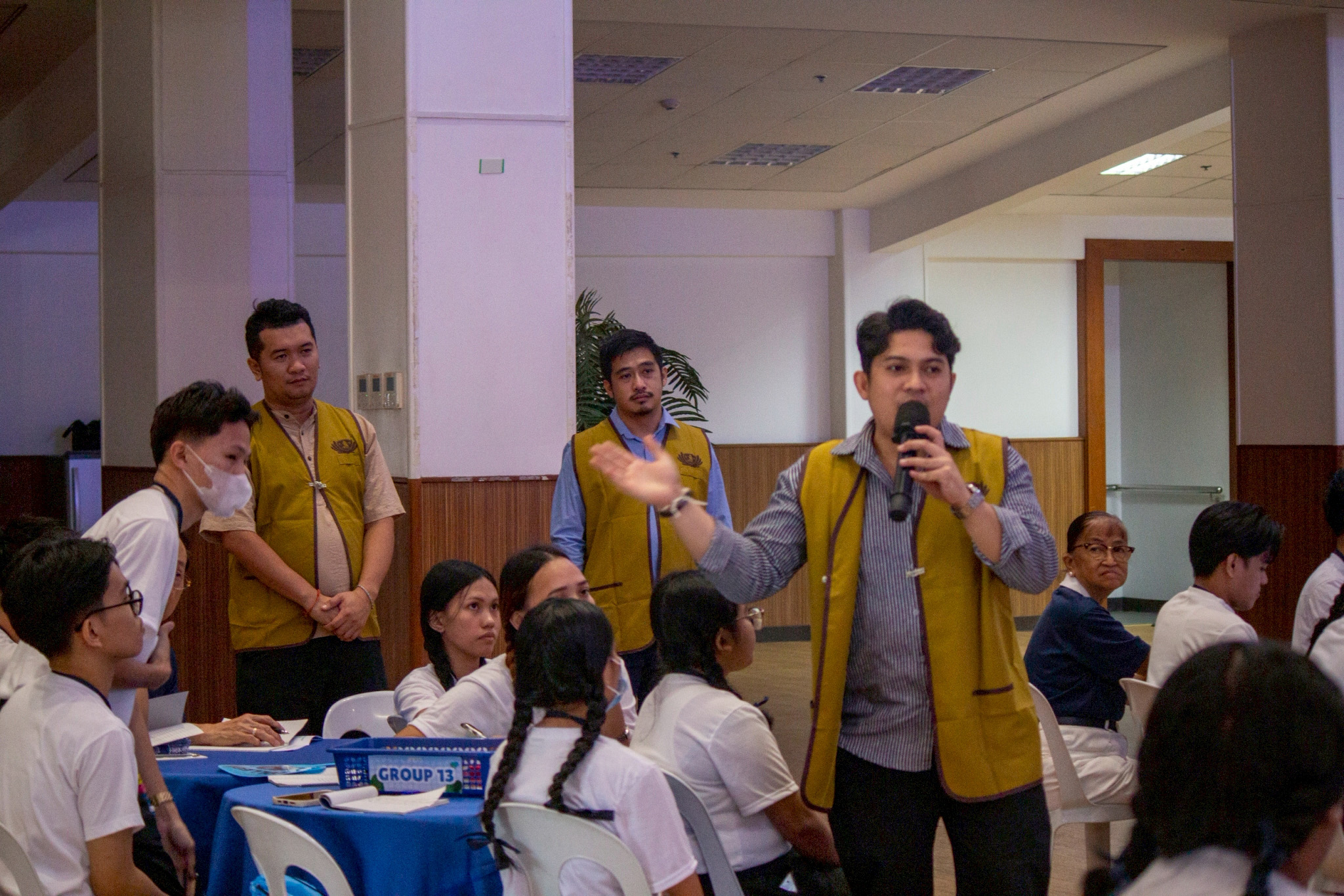 Sporting Tzu Chi volunteer vests, James Nathaniel Refugio, Gabriel Rafael Viray, and Aron Sedrick Caminong of Tzu Chi International Youth Leadership Program (IYLP) discuss Sustainable Development Goals with scholars. 