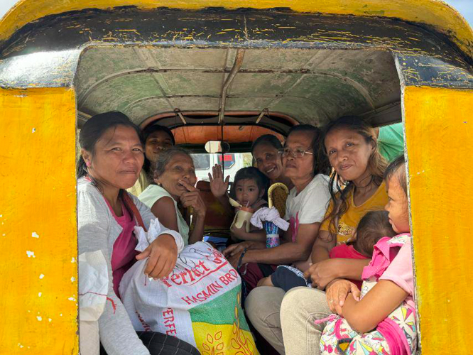 Beneficiaries in Aparri head home together, bringing the relief goods they received. 