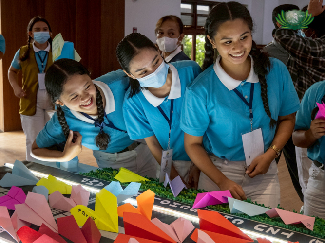 After writing their vows on their paper planes, scholars place them on a symbolic runway.