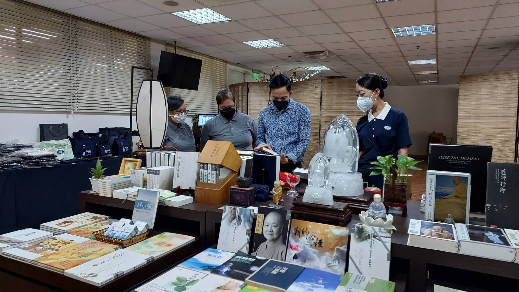 Flanked by Tzu Chi volunteers (from left) Tina Pasion, Dolly Alegado Cruz and Peggy Sy (extreme right), Mayor Shierwin Taay of Dingalan, Aurora, checks out items in the Tzu Chi bookstore.【Photo by Jerom Bacarra】