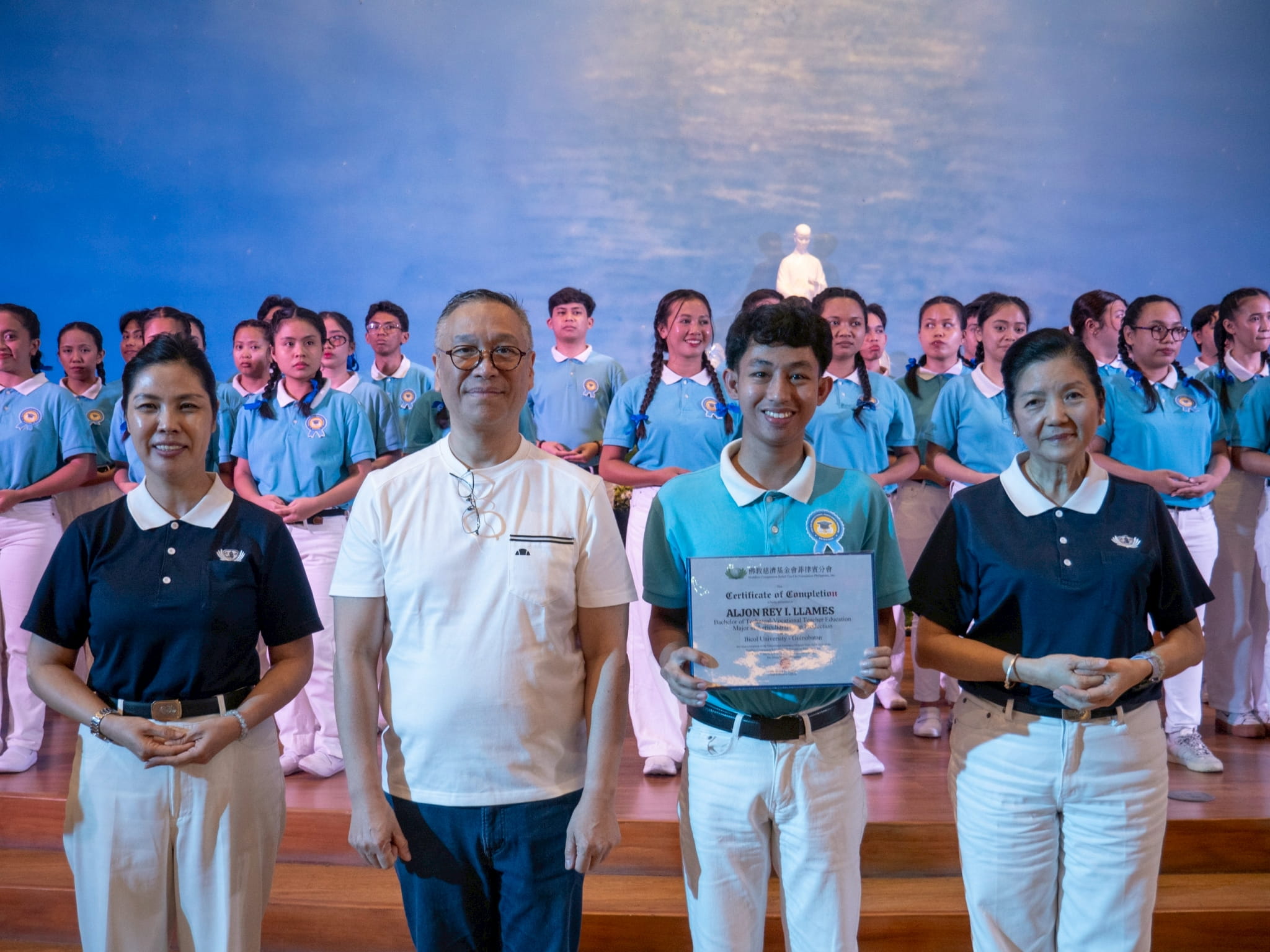 Regan Industrial Sales, Inc. CEO Regan Sy (second from left) participates in presenting scholars with their certificates. He is joined by Tzu Chi Pampanga volunteer Pansy Ho (left) and Rosa So, head volunteer for the educational and medical assistance programs (right).