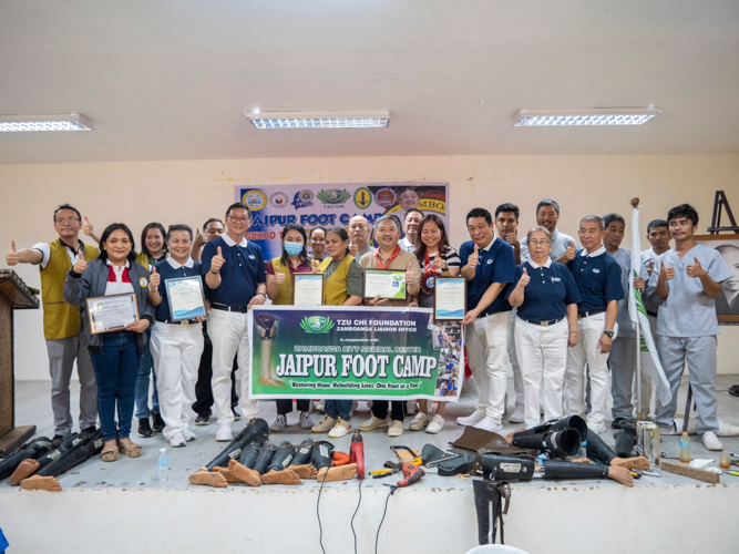 Tzu Chi Zamboanga volunteers, prosthetic technicians, volunteer doctors, and physical therapists from Zamboanga City Medical Center, and members of the Persons with Disabilities Affairs Office posed for a photo with Zamboanga del Sur Governor Victor Yu (center, in brown shirt) and Congresswoman Divina Grace Yu (beside Gov. Yu, in striped shirt). 