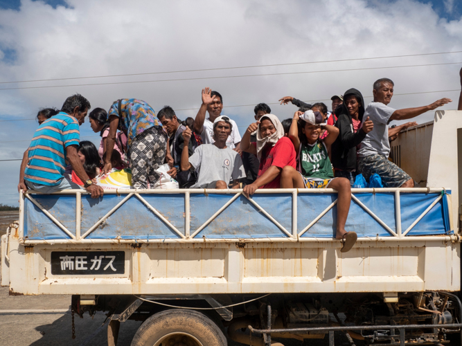 Beneficiaries in Aparri head home together, bringing the relief goods they received. 