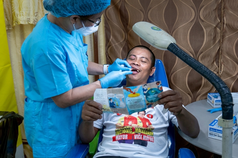 A  dental patient distracted himself from the fear and pain of an extraction by reading a Tzu Chi pamphlet during the procedure.