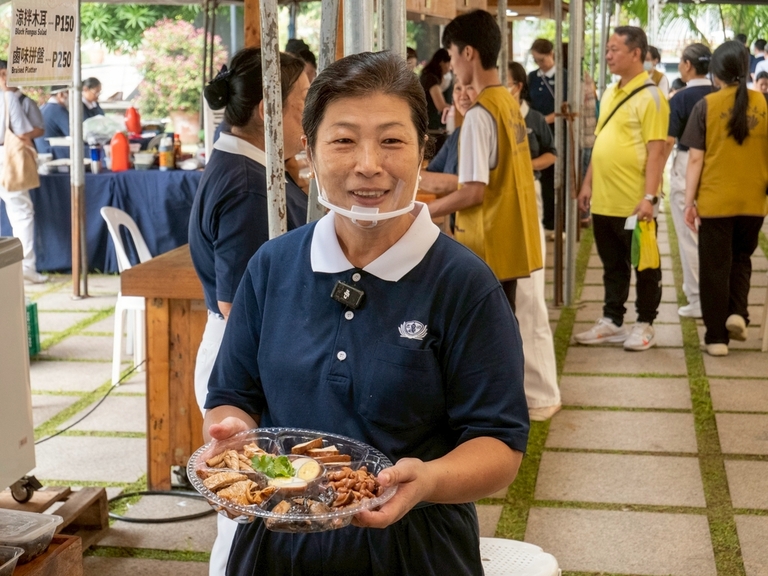 Vivian Chua holds up a braised platter of appetizers that included peanuts, veggie meat, tofu, mushroom, and egg.