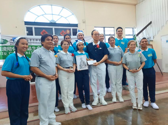 Tzu Chi Bicol volunteer Antonio “Tony” Tan hands out special prizes to raffle and contest winners at Tzu Chi Bicol’s Christmas party. 【Photo by Tzu Chi Bicol】