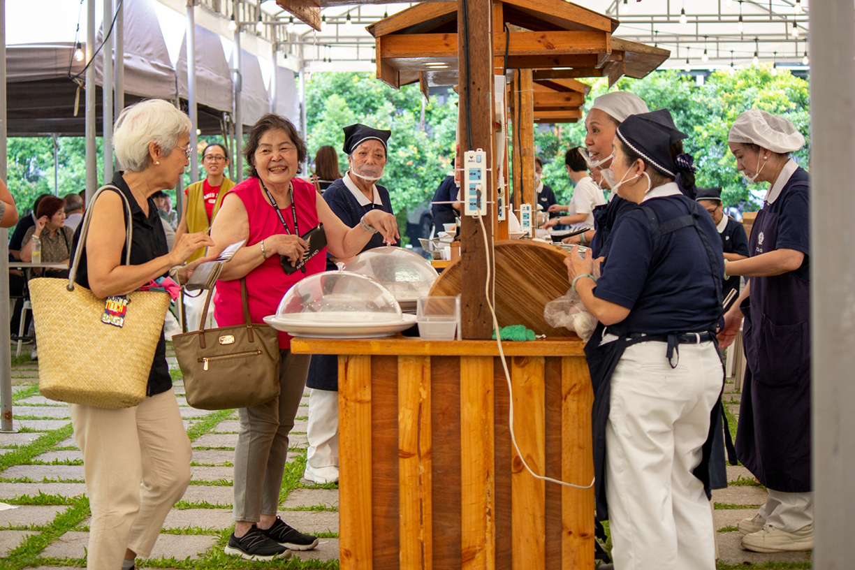 Visitors and shoppers happily indulge in a vibrant array of delicious vegetarian dishes, bringing flavorful life to the event.