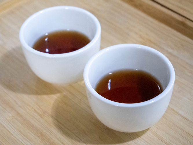 Two cups of tea are placed in each tray for the preschool students to serve to their parents.