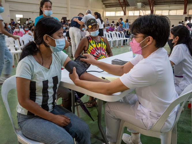 A patient is assessed by a volunteer medical practitioner at the registration area.