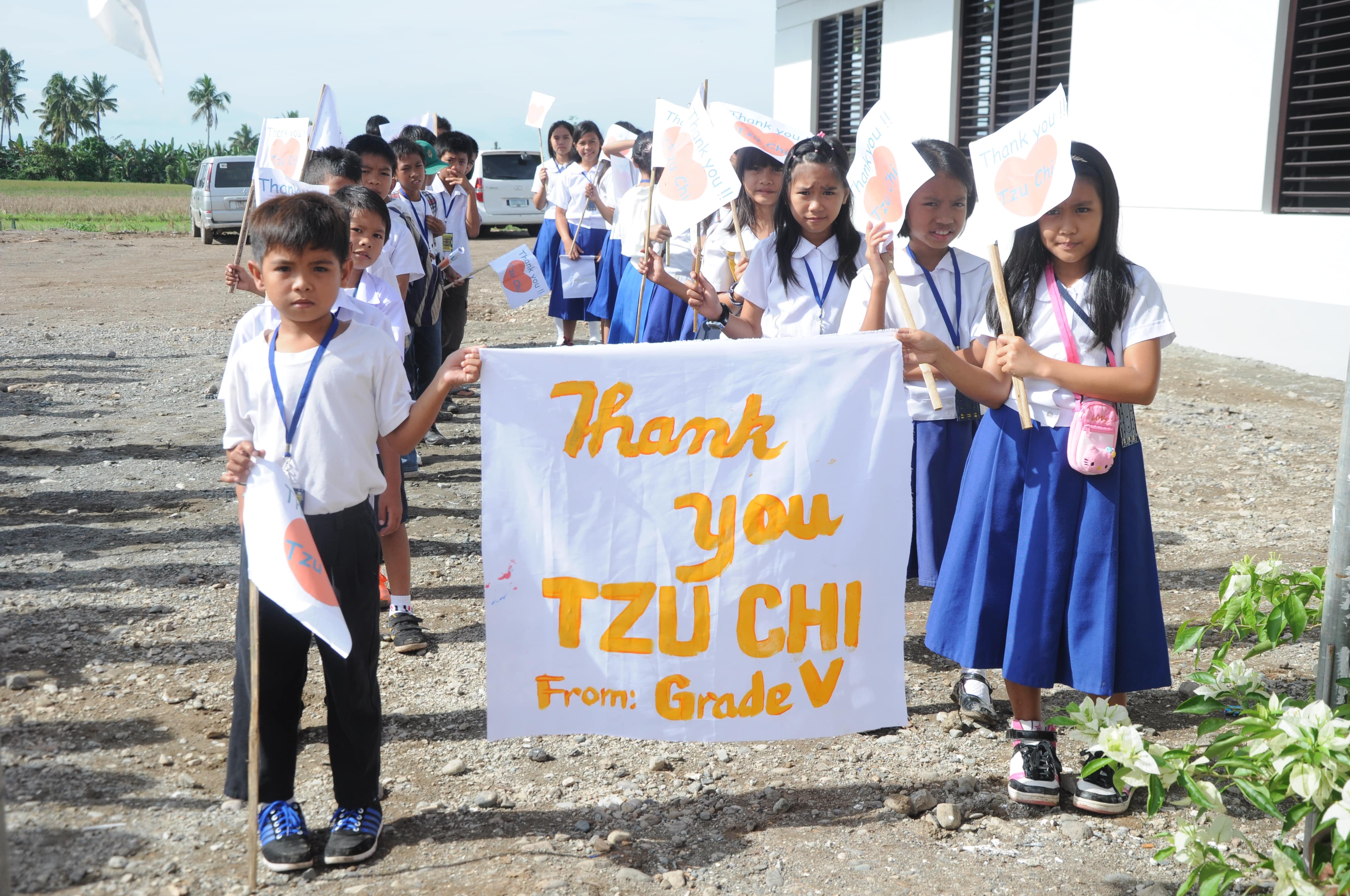 Mangayon Elementary School’s fifth graders form orderly lines to greet Tzu Chi volunteers in the turnover ceremony of their rebuilt school on December 1, 2014.