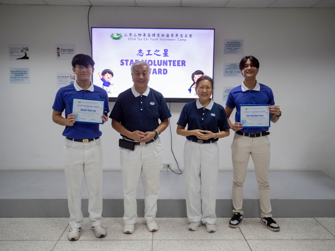 Alstein Lim (first from left) and Dan Perez (first from right) are recognized by Tzu Chi Philippines CEO Henry Yuñez and volunteer Sally Yuñez with a Star Volunteer Award for their participation in Tzu Chi activities. Alstein led the Mother's Day fundraising efforts in May, Dan led the tree-planting project this month.