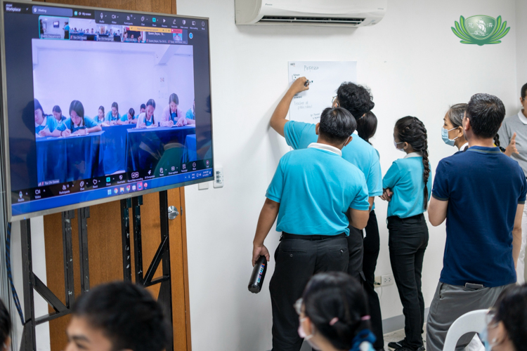 Scholars from Tzu Chi’s provincial chapters (on TV screen) join scholars at the Buddhist Tzu Chi Campus in Sta. Mesa, Manila, in writing their professional and personal aspirations on a piece of paper. 