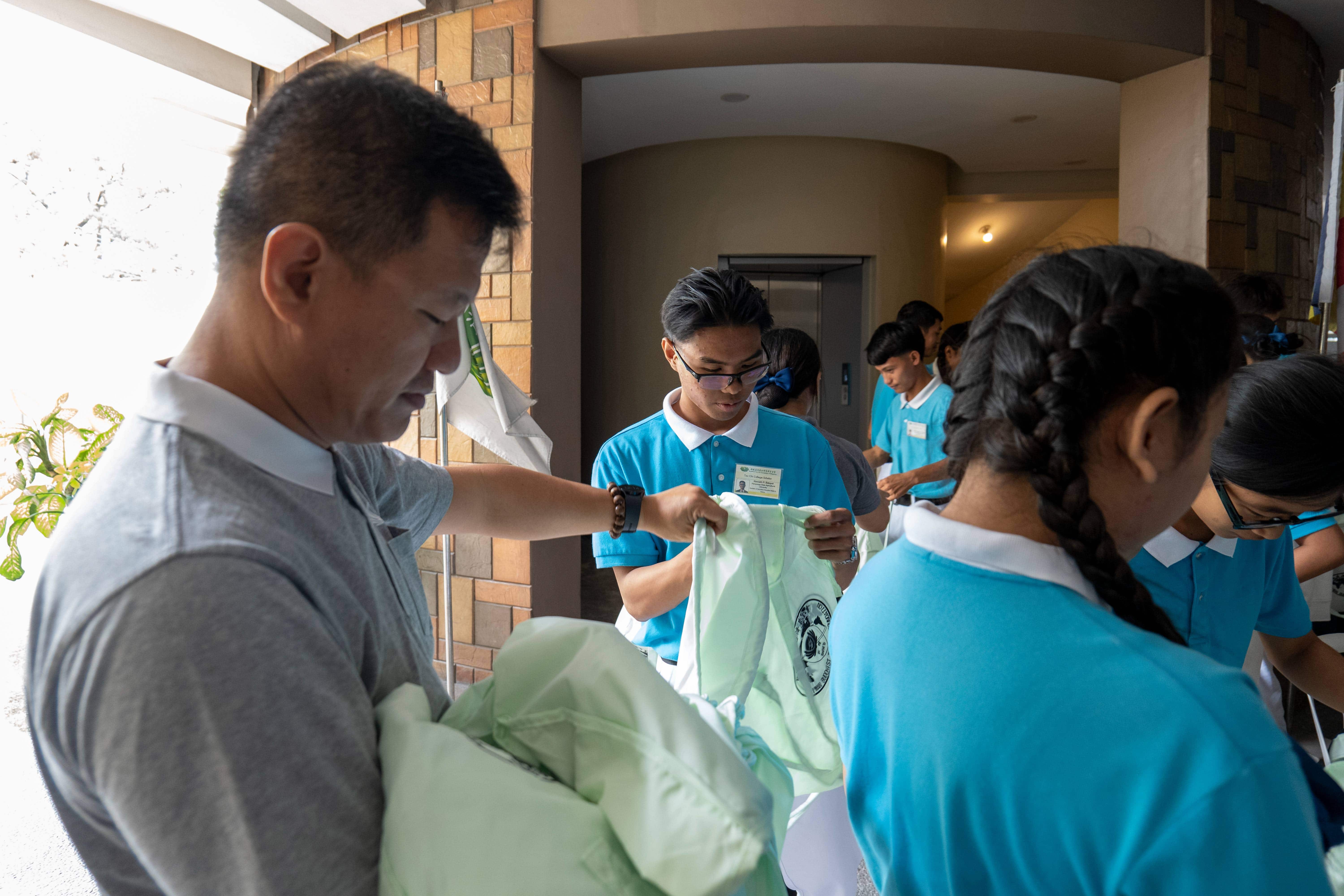 Kenneth Baluyut (center) carefully sorts out bags to be used during an outreach program at Villa Maria Integrated School in Porac, Pampanga.
