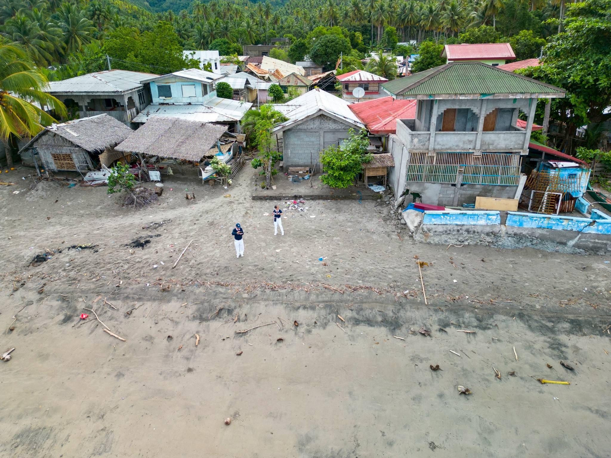 Tzu Chi volunteers stand by a shoreline whose waters have receded after the quake. 