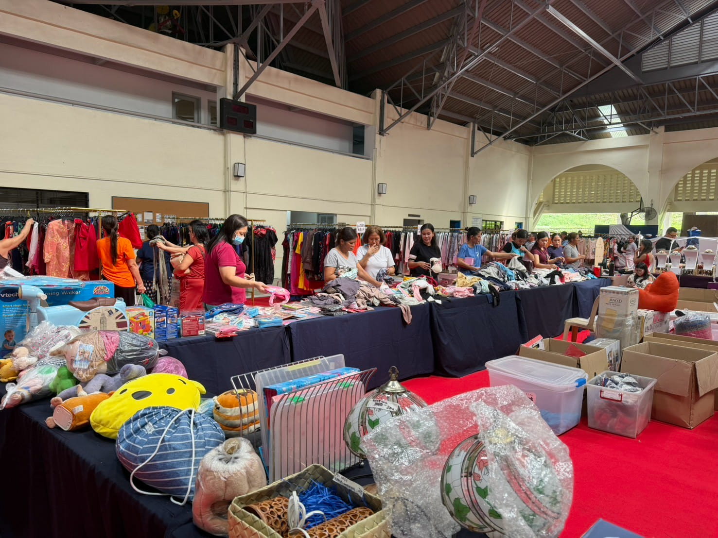 Shoppers browse a variety of items, from clothes and accessories to home essentials and toys. 