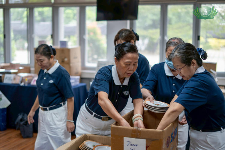 Volunteers carefully unload ceramic dinner ware from their boxes at Harmony Hall.