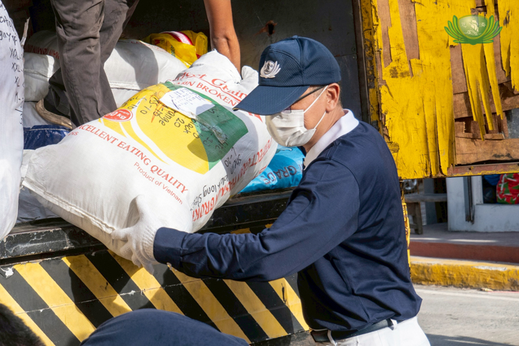 A Tzu Chi volunteer unloads sacks of relief items.