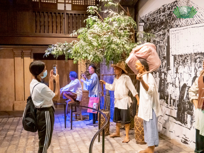 A scholar takes a photo of a life-size diorama of the earliest Chinese entrepreneurs in the Philippines.