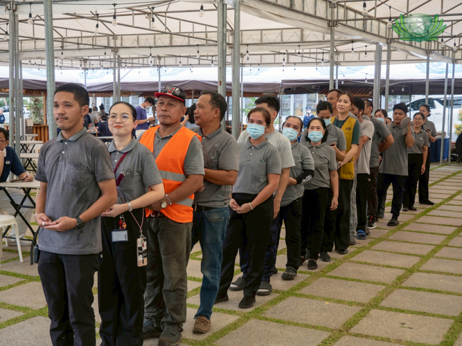 Employees eagerly wait for their chance to strike the gong in “Ring for Love.”