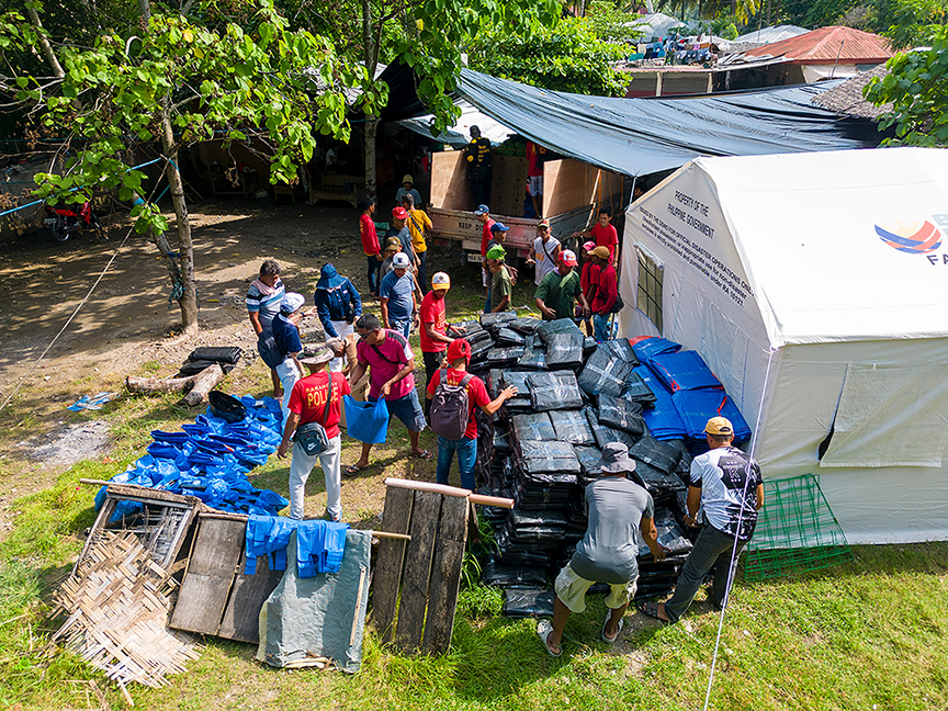 Volunteers help unload relief items at the grounds of Barangay Butulan in Jose Abad Santos. 