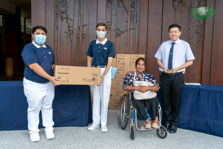 Marites Burce (seated), project coordinator of Tahanang Walang Hagdanan’s fundraising department, accepts Panasonic’s light bulb donations from Tzu Chi volunteers.