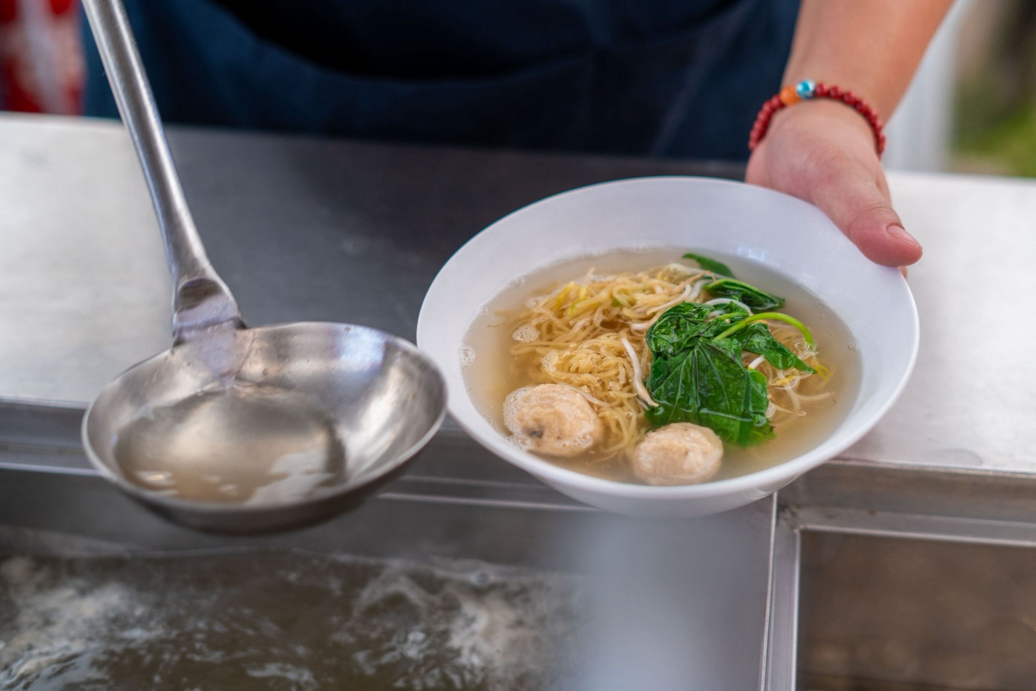 A simple clear soup with noodles, bean sprouts, leafy greens, and veggie balls makes a hearty meal. 