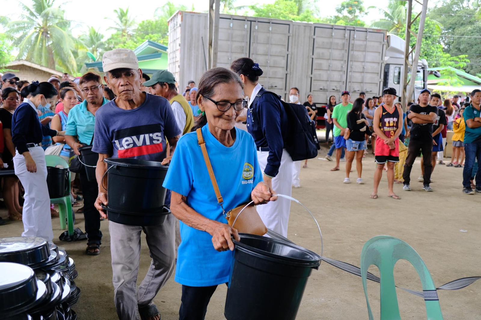 The beneficiary received a pail as a sign of her readiness to accept the goods.【Photo by Tzu Chi Davao】