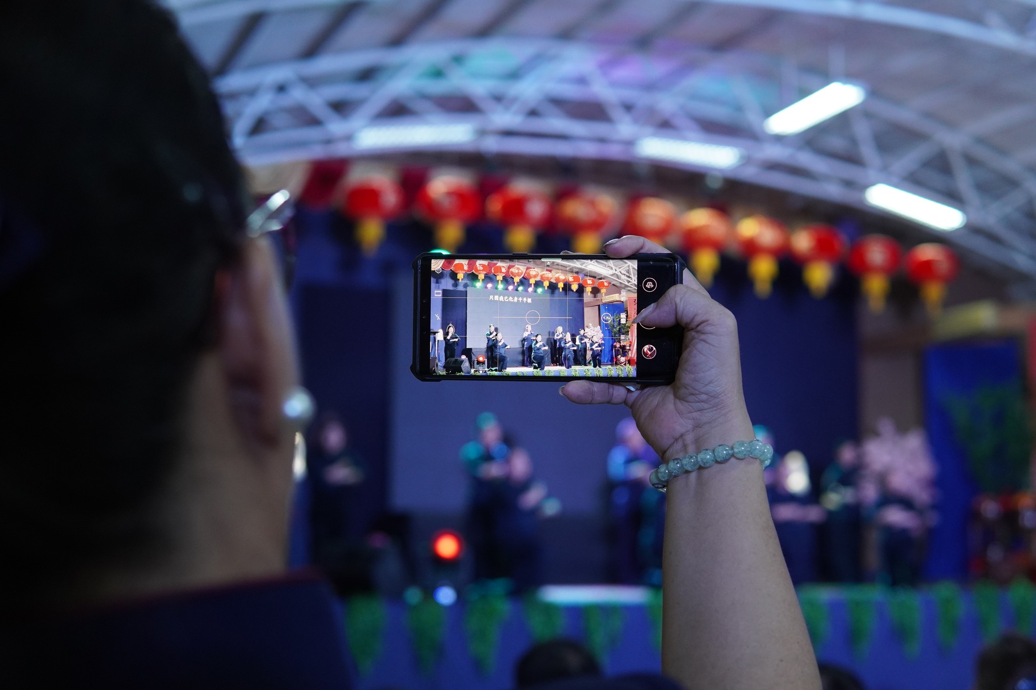 A proud mother, Tzu Chi Commissioner, Sis. Michelle Hsu captures video of the Tzu Chi Youths' performance.【Photo by Tzu Chi Davao】