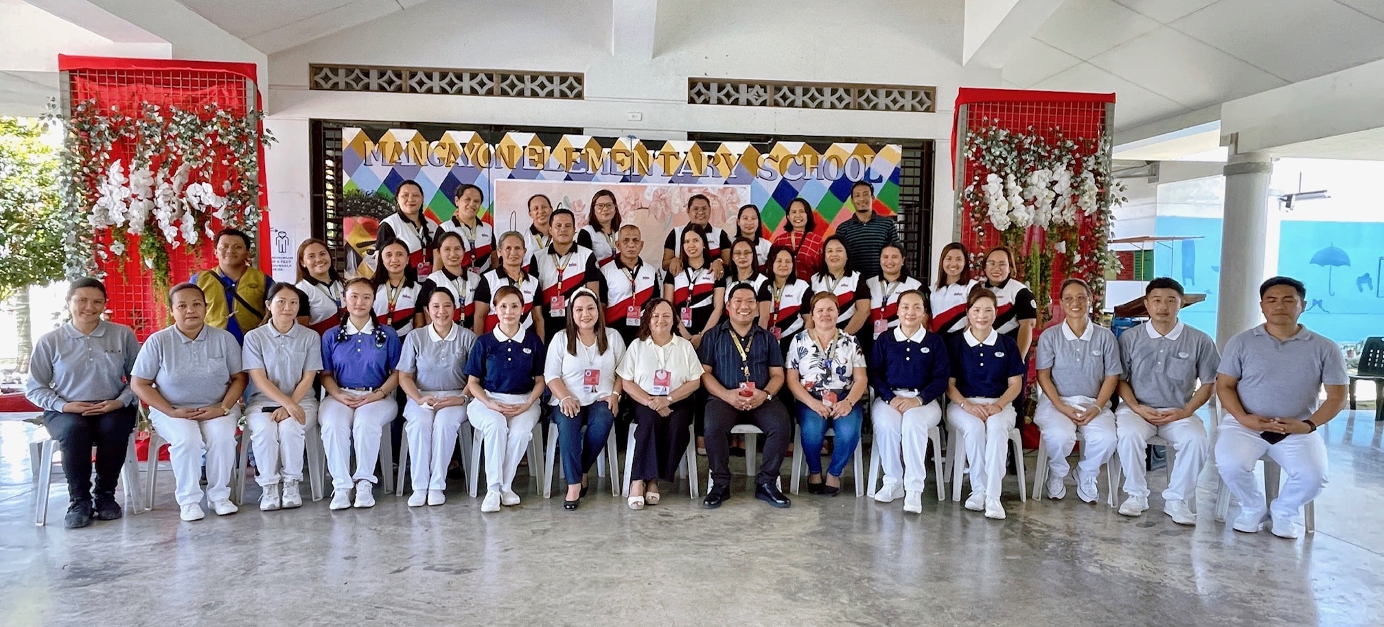 Mangayon Elementary School Principal 2 Sandy G. Yee (seated center, in dark shirt) joins faculty members and Tzu Chi volunteers in a group shot. (Photo from Mangayon Elementary School’s Facebook Page)