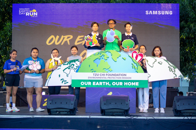 RunRio race organizer and coach Rio de la Cruz (sixth from left, in green) is flanked by Tzu Chi volunteers Molita Chua (fifth from left), Woon Ng (third from right), and Peggy Sy-Jiang (second from right), as well as sponsor representatives, in a Green Pledge. Together with runners, they committed “to protect all life on our planet, to live in harmony with nature, to share our resources justly, so that all people can live with dignity, in good health, and in peace.” 【Photo by Matt Serrano】