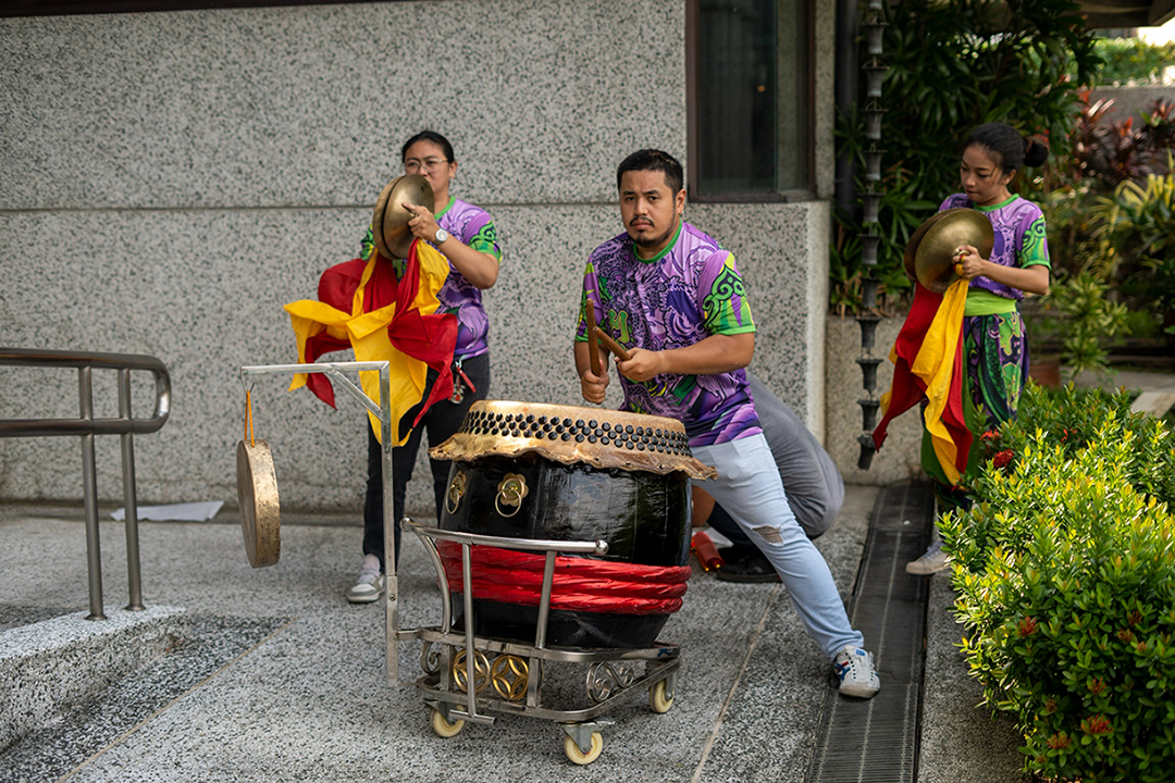 Members of the lion dance troupe play traditional drums, cymbals, and gongs to bring the performance to life.