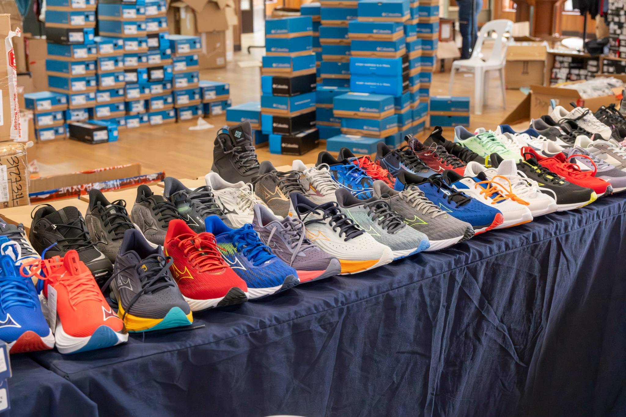 Footwear from popular brands like DC, Columbia, Roxy, and many more are neatly displayed on tables for shoppers to try on.