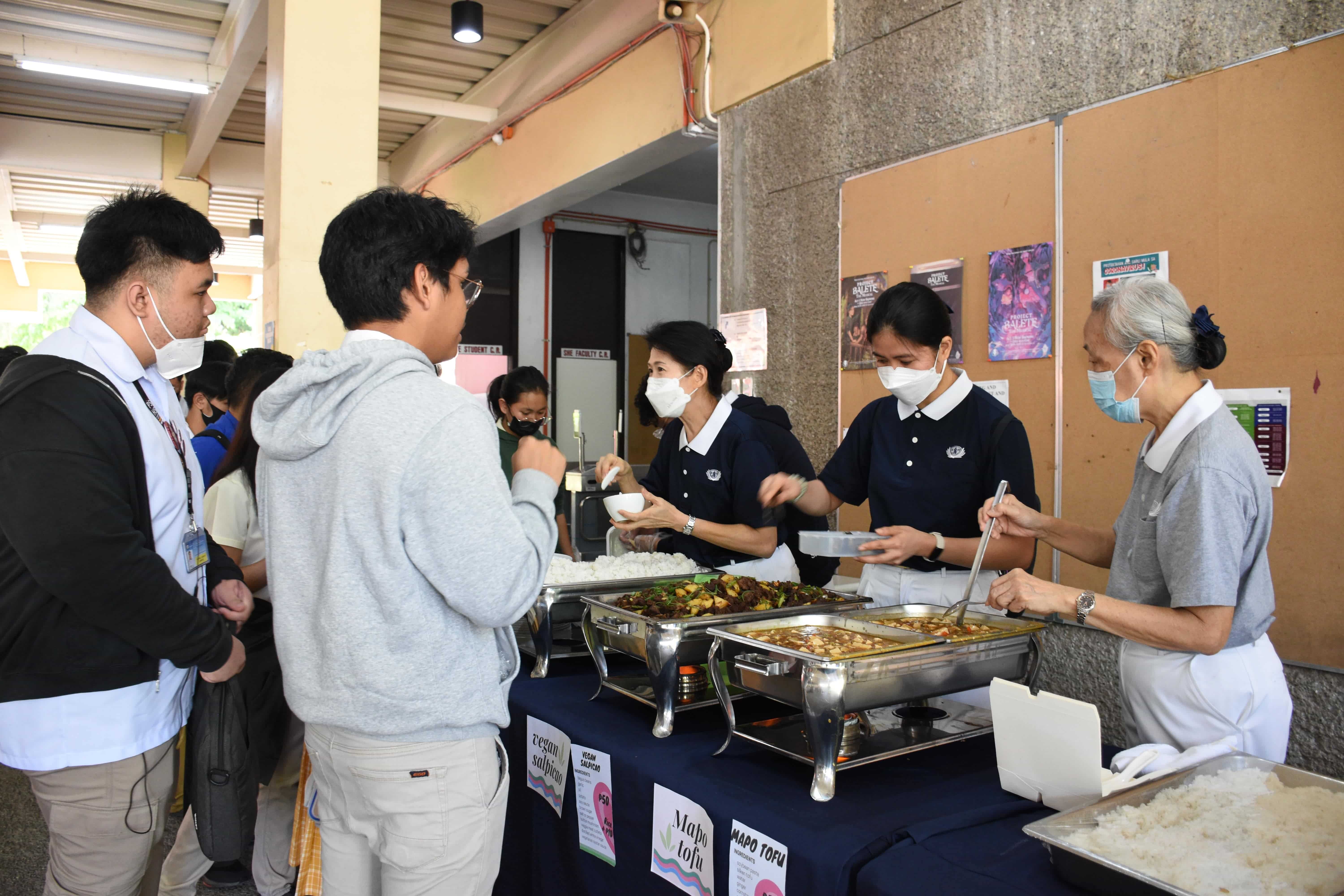 In the project “Plant-Powered Pisay,” Tzu Chi volunteers help students run a kiosk that sells vegan dishes to the Philippine Science High School community.【Photo by Lineth Brondial】