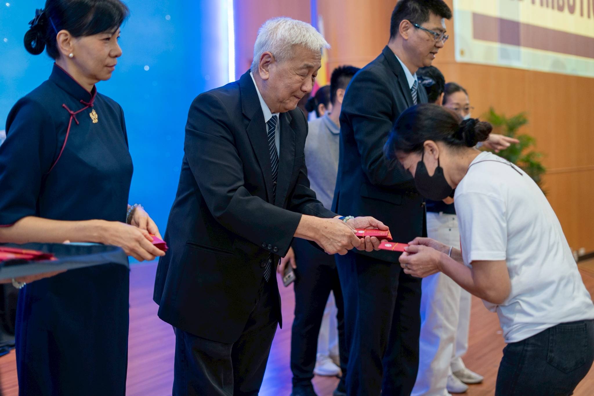Tzu Chi Philippines CEO Henry Yuñez (second from left) leads in the distribution of angpao (red envelope) among scholars and medical assistance beneficiaries. 